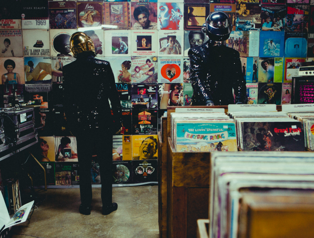 Thomas Bangalter et Guy-Manuel de Homem-Christo (Daft Punk) en casques de robots, penchés sur des bacs de vinyles chez un disquaire indépendant.
