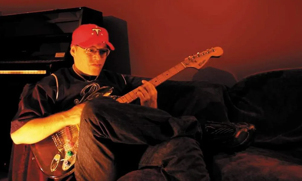 Portrait d'Éric Chedeville, alias Rico The Wizzard, cofondateur du label Crydamoure, posant dans un studio de musique.