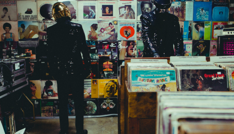 Thomas Bangalter et Guy-Manuel de Homem-Christo (Daft Punk) en casques de robots, penchés sur des bacs de vinyles chez un disquaire indépendant.