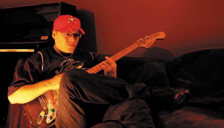 Portrait d'Éric Chedeville, alias Rico The Wizzard, cofondateur du label Crydamoure, posant dans un studio de musique.