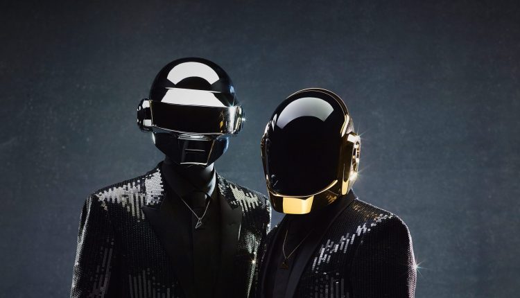 Portrait officiel de Daft Punk par David Black pour l'album Random Access Memories, montrant les robots en costumes de sequins noirs scintillants avec leurs casques emblématiques argent et or.